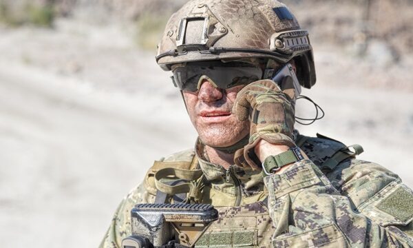 Army soldier calling Closeup shot of soldier calliong phone in the desert among rocks